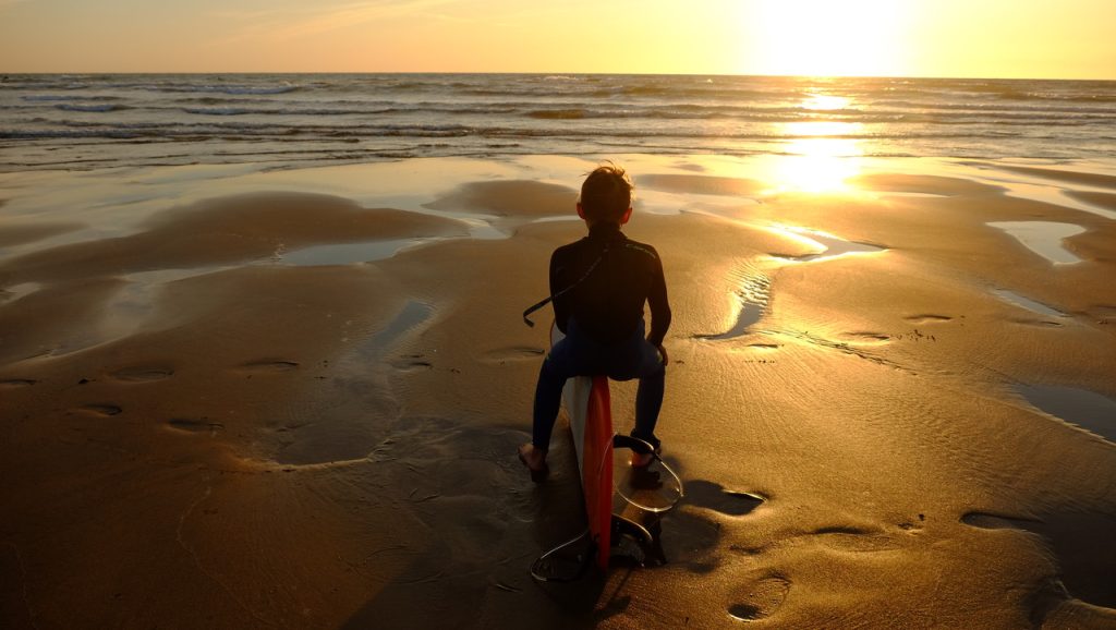 Beach sunset sitting on surfbaord